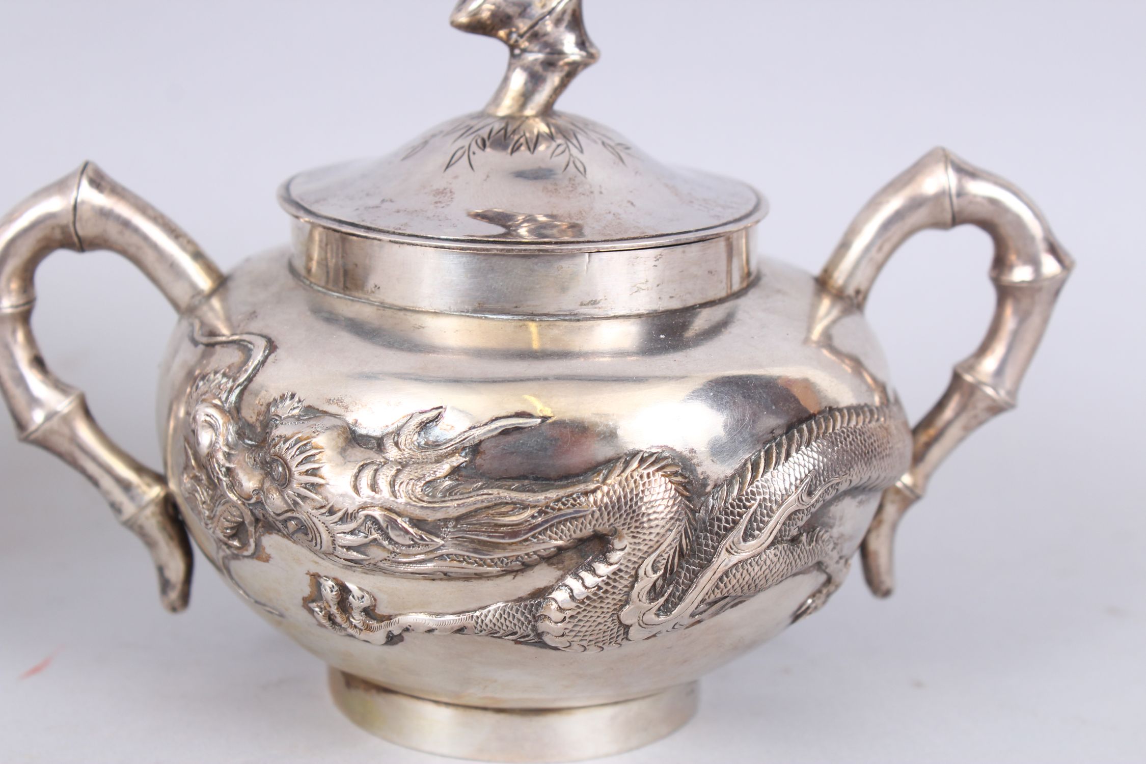 A GOOD CHINESE SILVER THREE PIECE TEA SET, decorated with dragon in