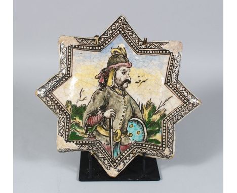 A PERSIAN QAJAR STAR POTTERY TILE, depicting a man resting on his gun, 30cm.