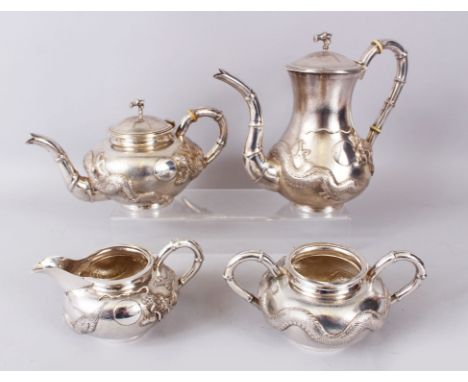 A HONG KONG C.J. CO FOUR PIECE SILVER TEA SET, hammered silver with a dragon in relief, comprising teapot, hot water jug, mil