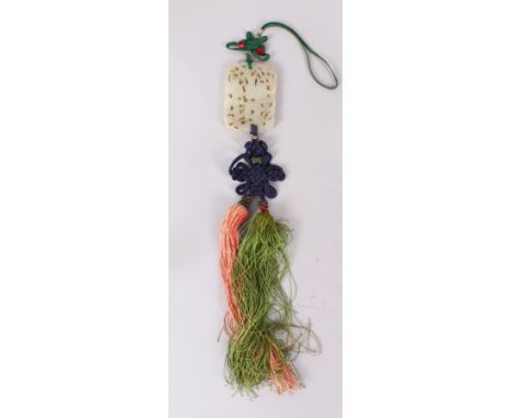 A GOOD CHINESE JADE PIERCED AND CARVED PENDANT,with attached silk drapes and tassels. 5cm wide x 7cm long.