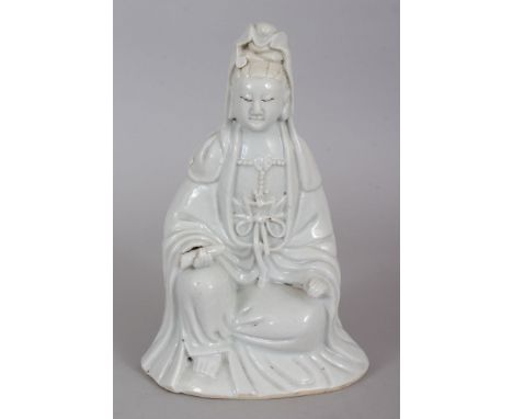 AN 18TH CENTURY CHINESE BLANC-DE-CHINE PORCELAIN FIGURE OF GUANYIN, seated in meditation and bearing a scroll, the base ungla