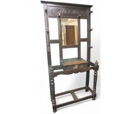 A late Victorian stained oak mirror back hall stand with central bevelled glass mirror pane flanked by four turned coat pegs 