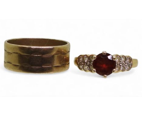 A 14k gold garnet and clear gem set ring, size K, weight 2.6gms, together with a wide 9ct wedding band size M1/2, weight 3.5g