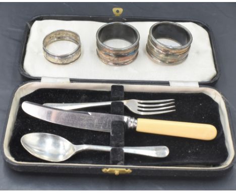 A child's cased HM silver spoon and fork bearing dated presentation inscription with additional knife, and three HM silver na
