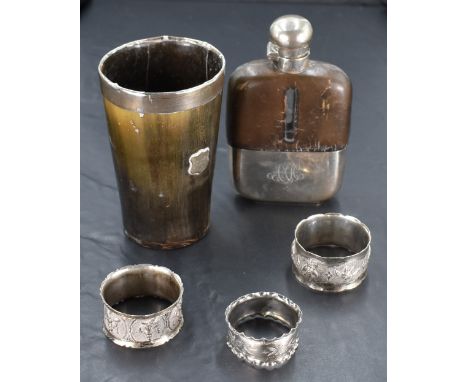 A small selection of silver and white metal including three napkin rings, an Edwardian glass and leather hip flask having sil