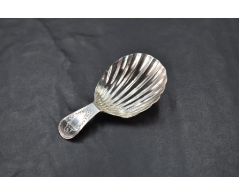 A George III silver caddy spoon, of fluted scallop form with short bright-cut handle, marks for London 1788, maker probably T