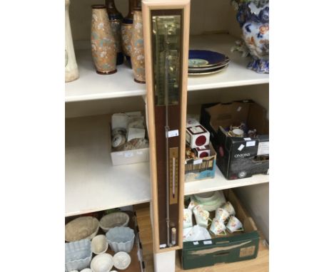 A modern barometer, brass, glass with mercury with wooden frame