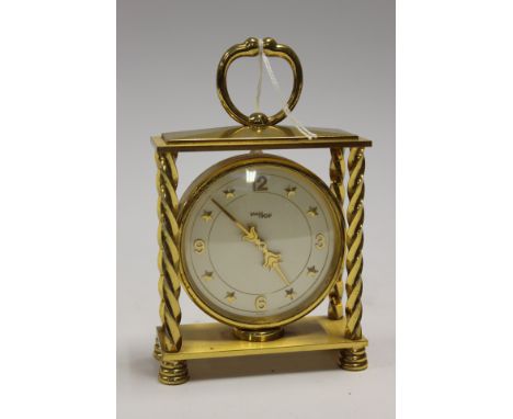 An Imhof gold plated Swiss made mantle clock with carriage handle