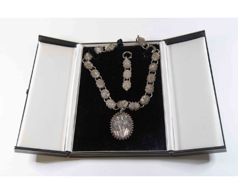 A Victorian silver locket and chain in the aesthetic style, the oval locket cast daisies and overlaid with two colour gold, o