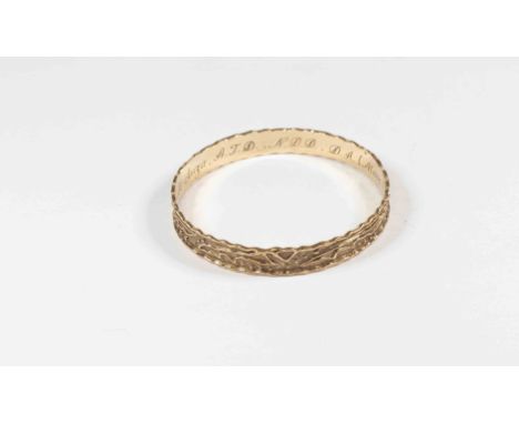 A yellow metal bangle stamped 9k, with applied decoration, waved edge, width approx 9mm, internal diameter approx 65mm, with 