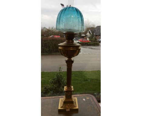 A Victorian brass double wick oil lamp, complete with blue glass shade and funnel, 85cm high