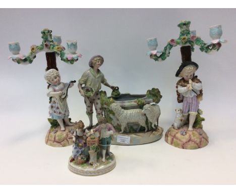A collection of porcelain figures including a pair of 19th Century candelabra modelled a boy playing a pipe and girl playing 