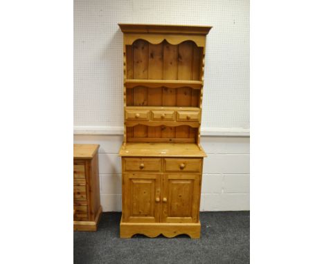 A Farmhouse pitch pine dresser of slim proportions, single shelf above three spice drawers, two small drawers to base above f