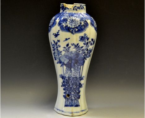 An 18th century Chinese fluted slender baluster vase, decorated in underglaze blue with peonies and other foliage in a vase, 