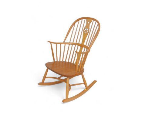 An Ercol Millennium swan back blonde elm rocking chair, model 949, 60 by 76 by 104cm.Good condition. 