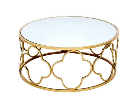 A modern mirror topped coffee table, the circular surface on a brass effect open frame base formed of quatrefoil shapes, 79 b