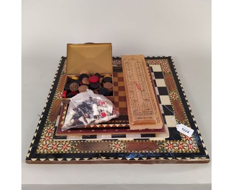 A hardstone chess board together the three light wood examples, two wooden cribbage boards, chess and draughts pieces