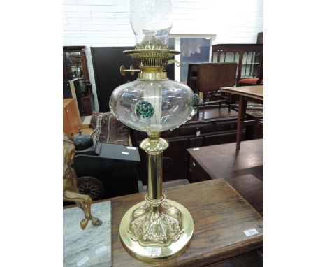 An Art Nouveau design oil lamp having art glass reservoir on piller and scroll base
