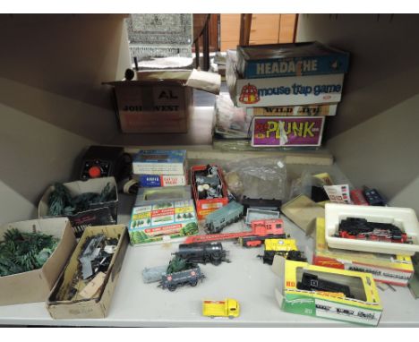 A shelf of HO and OO gauge rolling stock and accessories including Fleichmann 0-6-0 tank engine and dock shunter, both boxed