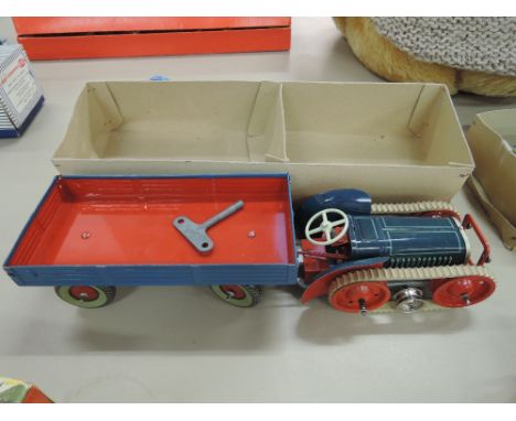 A mid 20th century Gesha tin plate and clockwork tractor and trailer in blue and red with yellow and chrome headlights, boxed