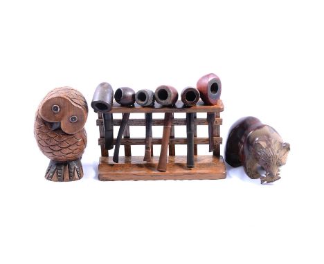 Box of wooden items including a smoker's pipe rack with pipes, carved wooden figures, brackets, a leather-clad triangular bot