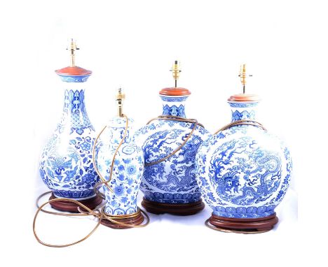 Four modern Chinese style blue and white table lamps, two flask form transferred with Dragon and pearl, wooden mounts, 41cm; 