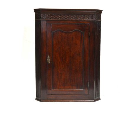 George III mahogany hanging corner cupboard, blind carved frieze, panelled door, width 78cm, height 104cm.