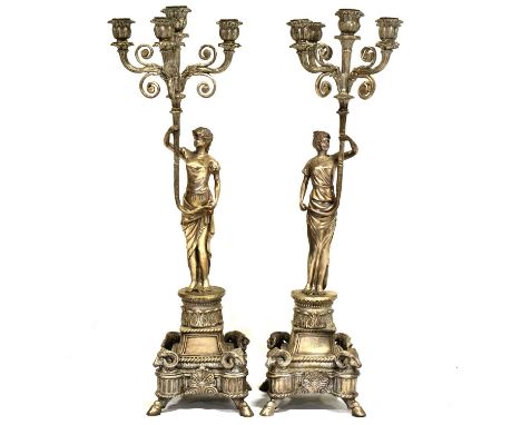 Pair of large silvered metal figural five-light candelabra, the scrolled sconces supported by a maiden, raised on a stepped b