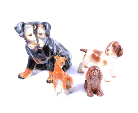 Salt-glazed model of a seated spaniel, 15cm, and collection of other ceramic dog figurines including a fireside seated puppy.
