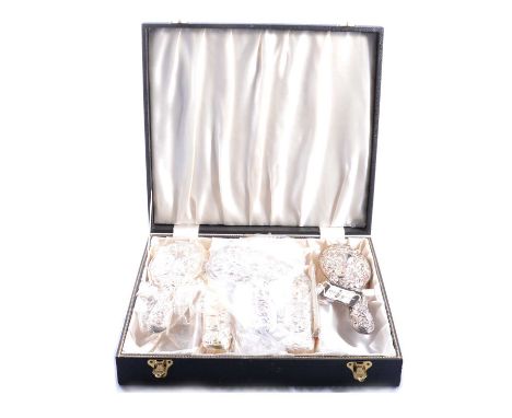 A silver backed cased six piece dressing table set, Broadway silverware, Birmingham 1989, repousse chased design with vacant 
