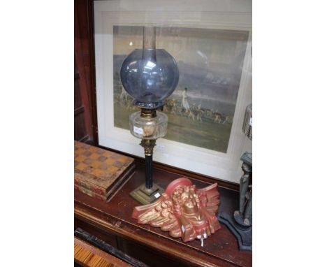 A 19th century oil lamp with blue shade and a painted plaster cherub wall light
