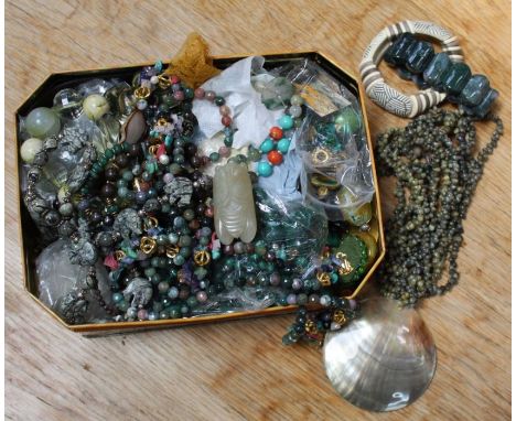 A tin of various costume jewellery, to include hardstone bead necklaces, amongst them malachite and jade