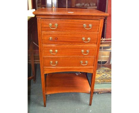 A first quarter 20th century mahogany four drawer music cabinet, on four slender legs, united by an undertier