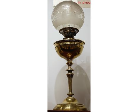 An early 20th century brass pedestal oil lamp, having opalescent globular glass shade