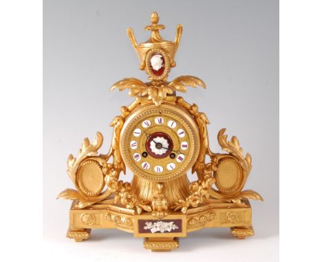 A Victorian gilt metal mantel clock under glass dome, the clock surmounted with a neo-classical pedestal urn, the dial with p