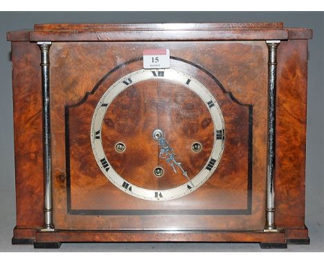 An Art Deco walnut cased mantel clock, having a silvered chapter ring with Roman numerals and eight day movement striking on 