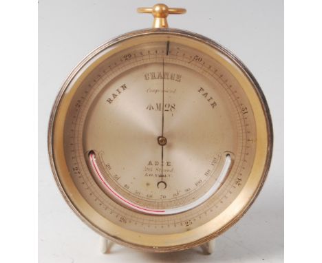 A late 19th century lacquered brass cased cylindrical compensated barometer, the silvered dial with thermometer with broad ar