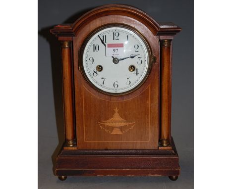 An Edwardian mahogany and satinwood inlaid cased mantel clock of architectural form having a convex enamel dial with Arabic n