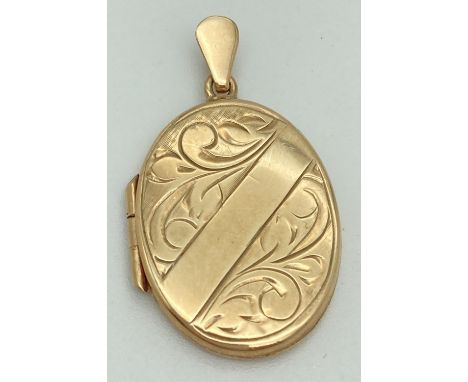 A 9ct gold oval shaped locket with engraved scroll detail to front. Fully hallmarked to hanging bale with 375, scales &amp; a