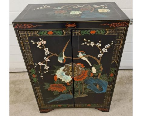 A vintage Chinese black lacquer 2 door cupboard with hand painted floral &amp; bird detail. With decorative brass handles and