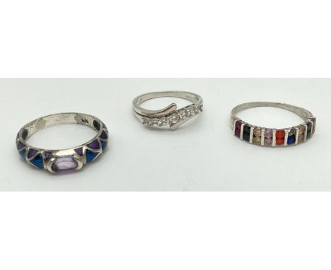 3 large size stone set silver dress rings. A crossover band style set with clear stones, a half eternity style ring set with 