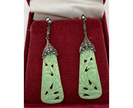 A pair of antique carved jade drop earrings with 935 silver mounts set with marcasites. Screw back fixings and tear drop shap