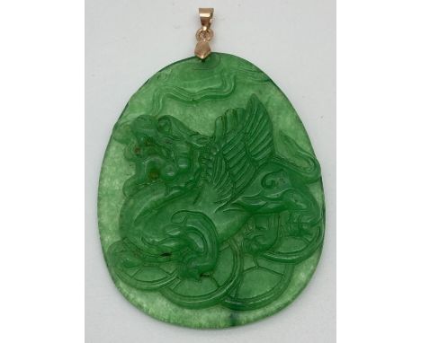 A carved jade pendant, with yellow metal bale, designed with Chinese dragon carving to one side. Approx. 6.5cm long (inc bale