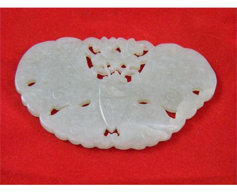 A small carved green stone panel, possibly Jade, depicting a butterfly, approx 9cm x 5.5cm.