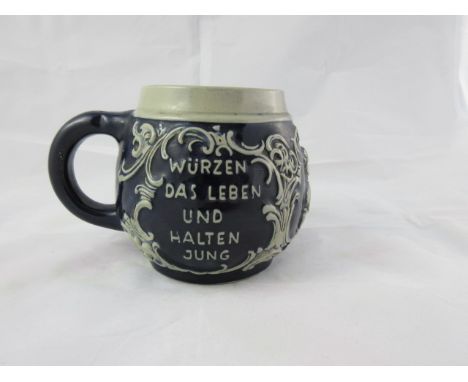 A C19th German earthenware Mug or Measure, moulded decoration depicting a kissing couple and “Wurzen das leben und halten jun