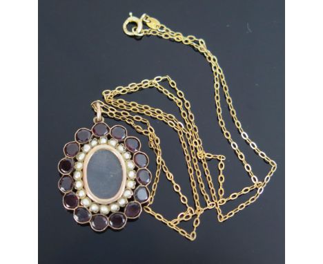 An Antique Garnet, untested Spilt Pearl and Gold Mounted Mourning Locket Pendant, of oval form, glazed central aperture, hing