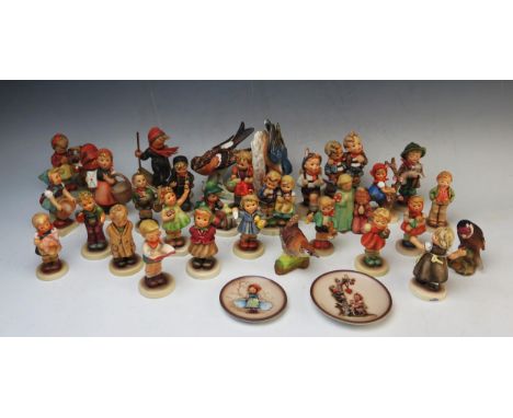 A collection of Goebel figurines, including Hummel skiing girl, school children, circular plaques and bird ornaments. 