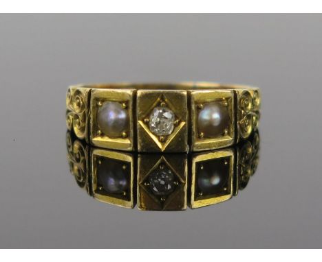 A Victorian Diamond, Seed Pearl and 18ct Gold Three Stone Ring with scroll decoration to the shoulders late 19th Century, rin