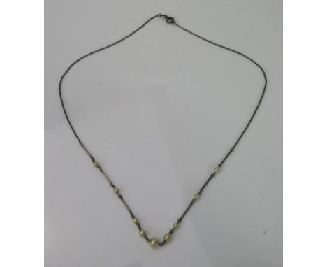 An Art Deco untested pearl and bar necklace, nine pearl (the largest 20mm), the clasp stamped AW Platinum, overall length app