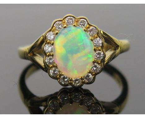 White Opal and Diamond Cluster Ring in an 18ct hallmarked gold setting, 9x7mm central stone, 13x11mm head, size O.5, 4.6g 